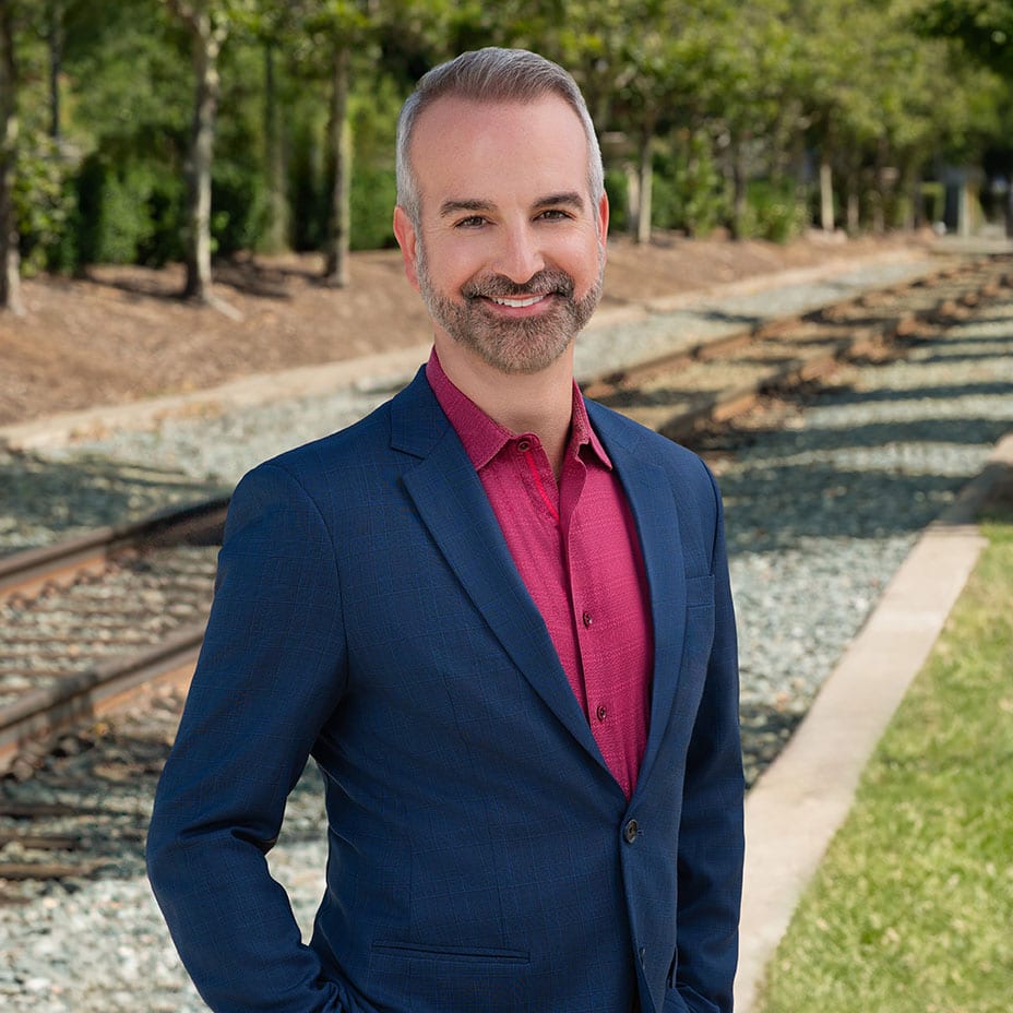 Jon Marshall stands in front of tracks for professional headshot