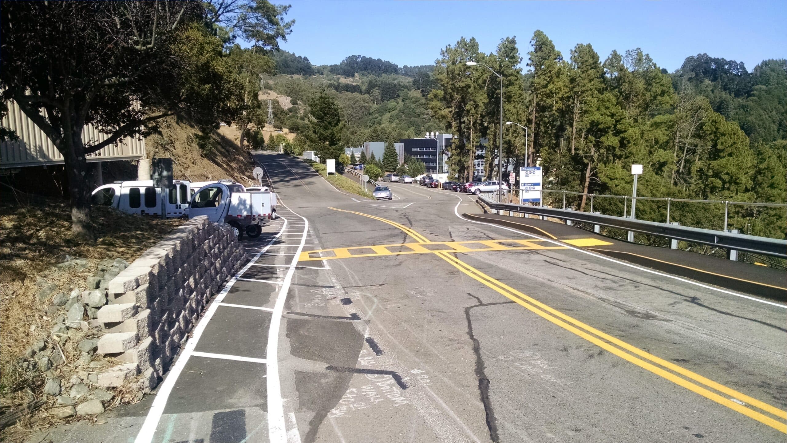 crosswalk striping on a hillside campus roadway