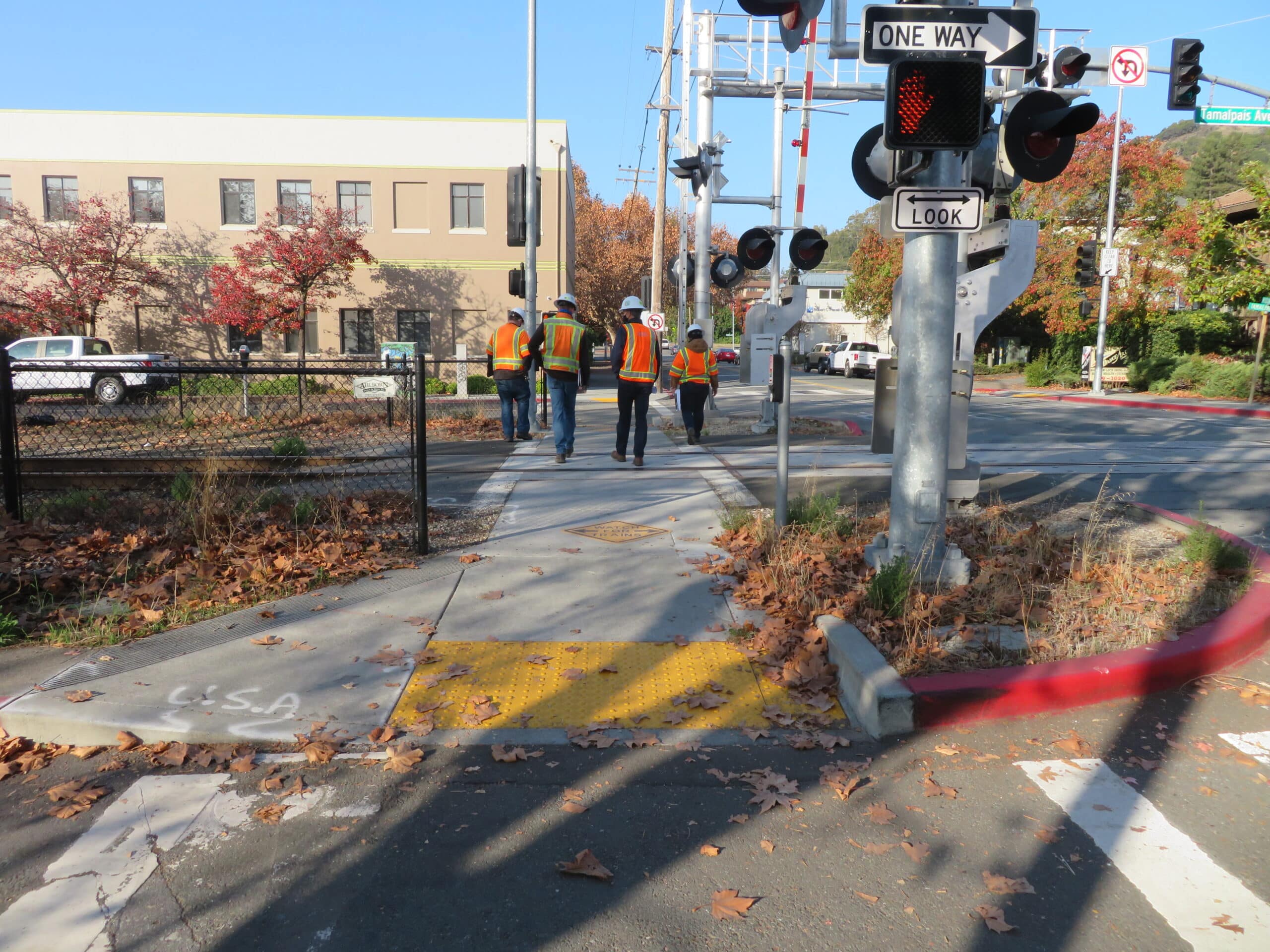 crew in protective gear meet at a railroad at-grade crossing