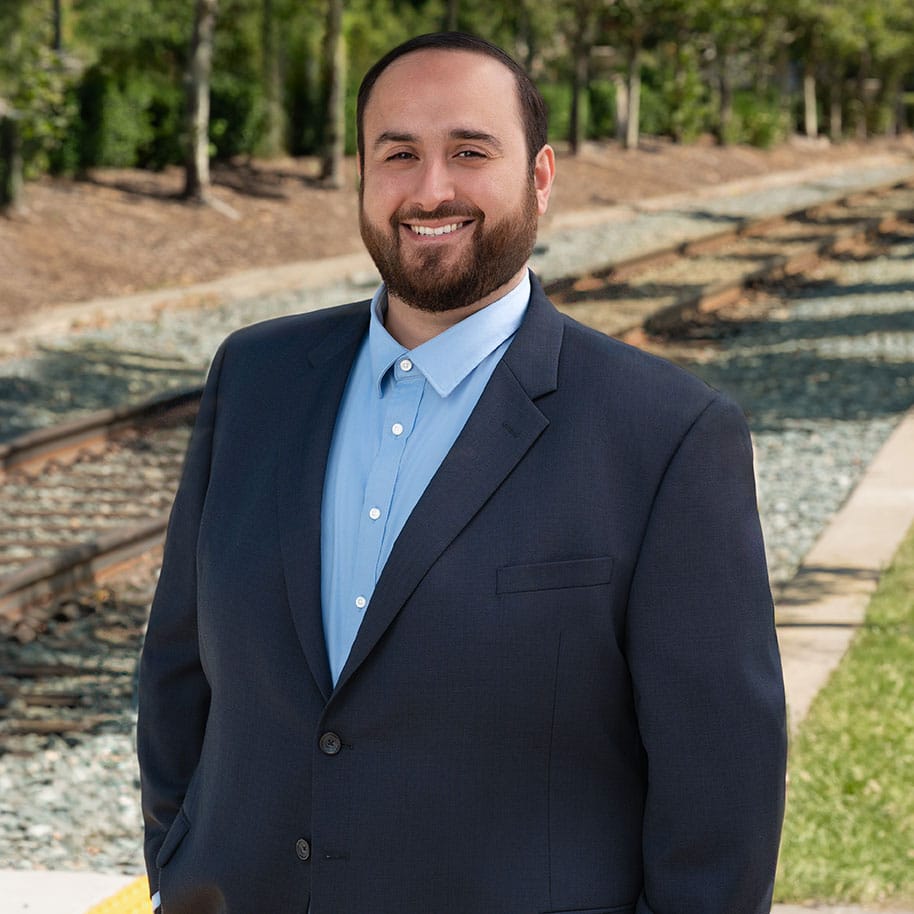 Mohammed Abushaban stands in front of tracks for professional headshot