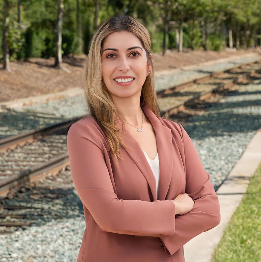 Araceli Reynoso stands in front of tracks for professional headshot